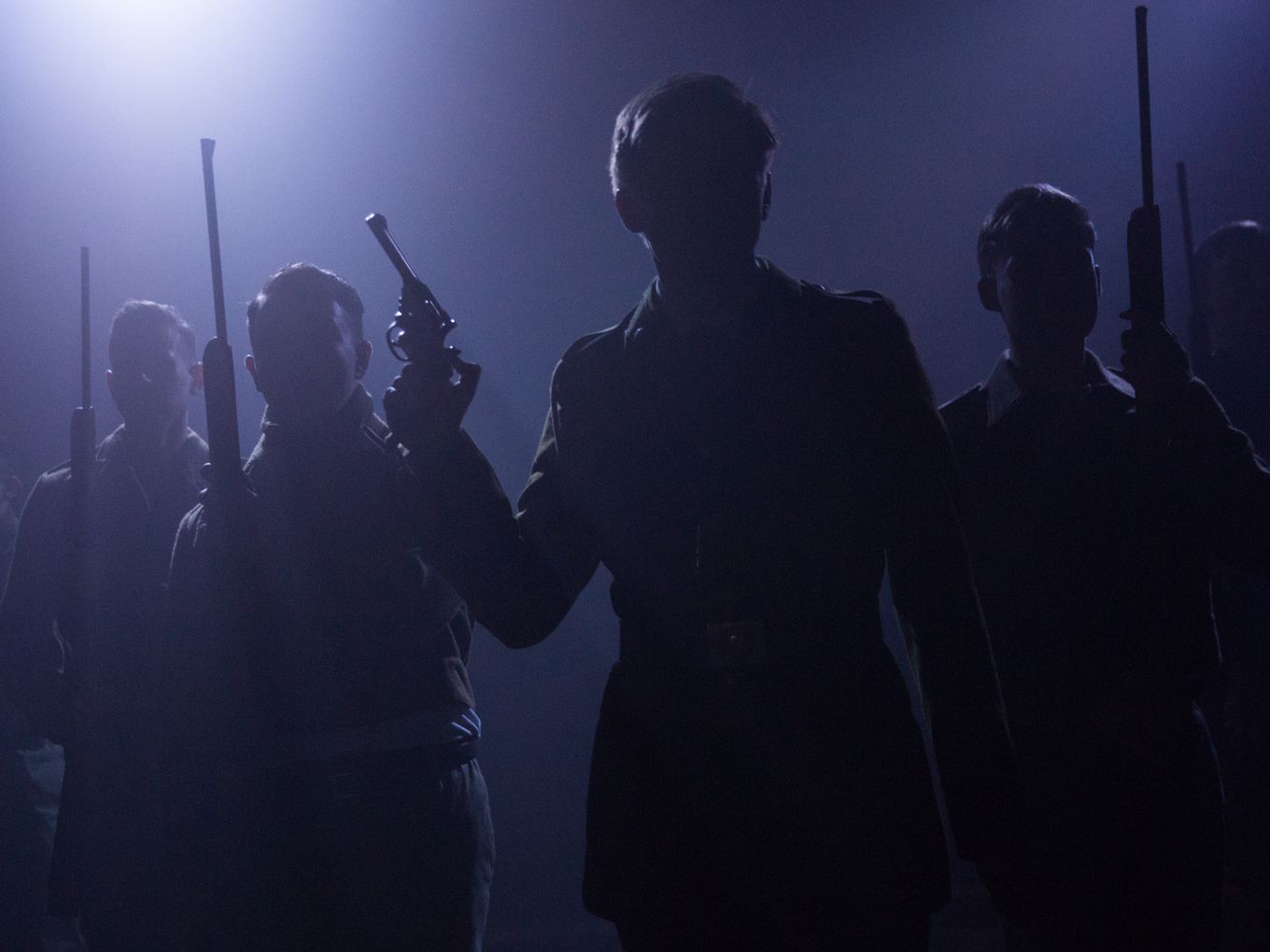 Men with guns silhouetted in a hazy dark purple light